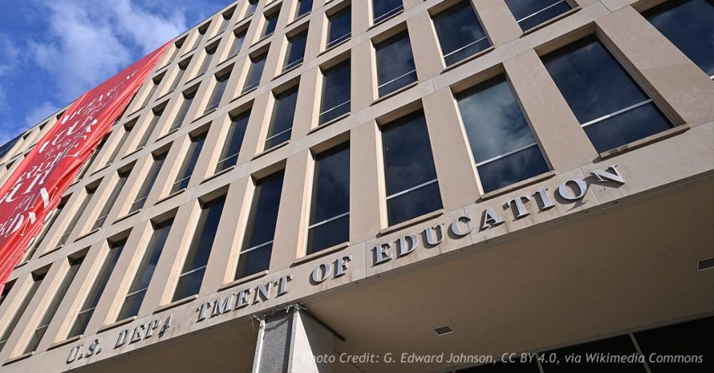 U.S. Department of Education headquarters building in Washington, D.C., viewed from below showing the agency's entrance sign.