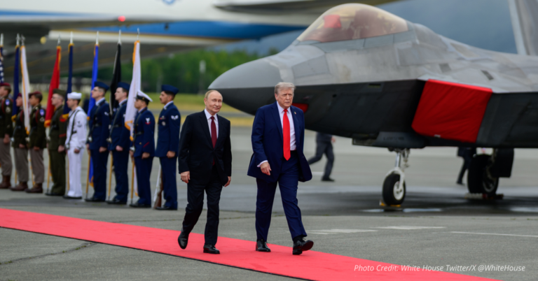Trump and Putin walk red carpet past stealth fighter at Alaska airbase.