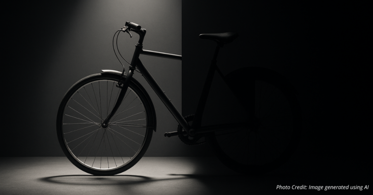 Half of a bicycle under spotlight symbolizing subsidy cuts