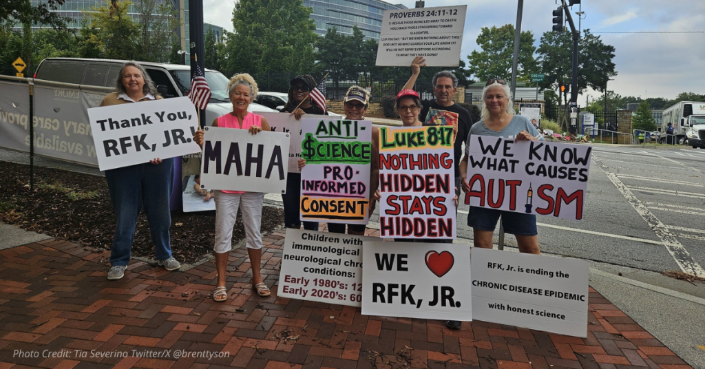 Supporters hold signs thanking RFK Jr. at rally