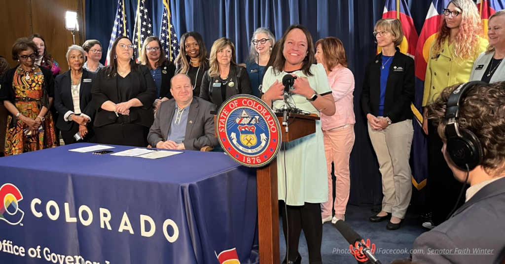 Senator Faith Winter at a press conference with Governor Polis.