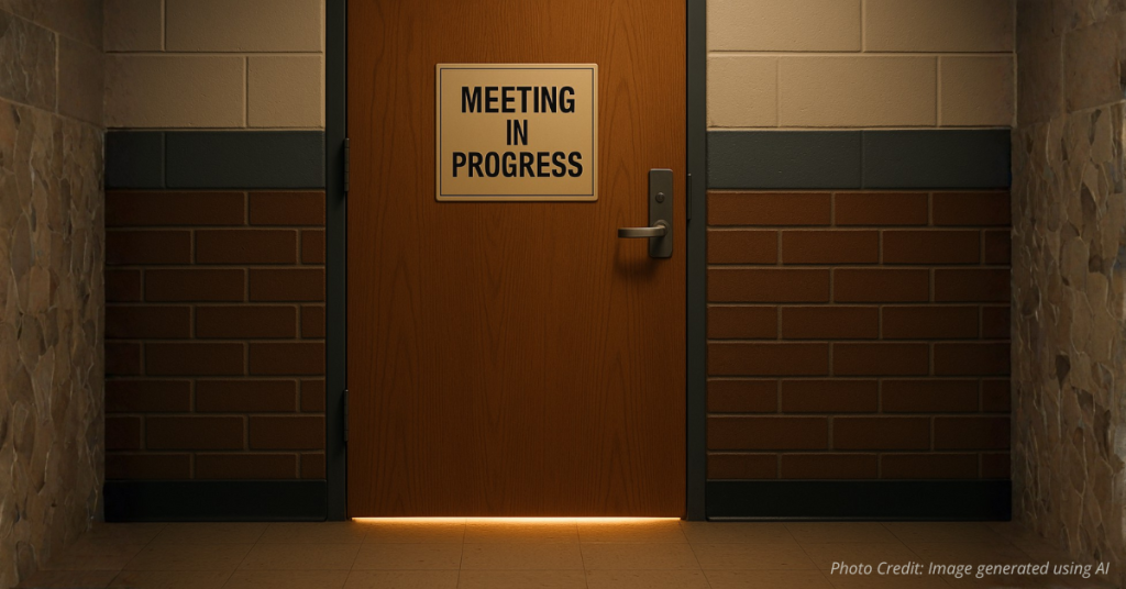 Closed classroom door with light symbolizing decisions made behind the scenes