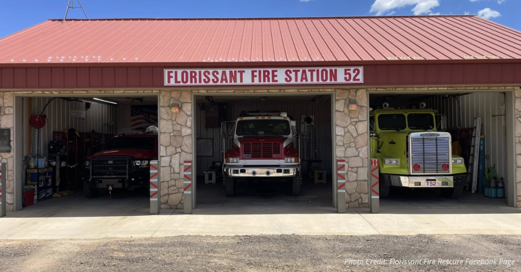 Florissant Fire Station 52 with three fire apparatus parked inside open bays under a red metal roof