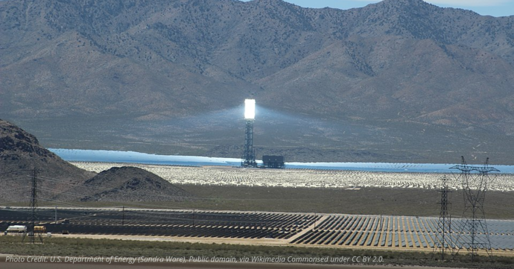 Brightly lit solar power tower at Ivanpah Solar Electric Generating System surrounded by reflective mirrors in the Mojave Desert