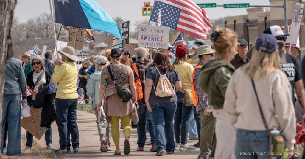 Protesters gather with signs and American flags during a No Kings demonstration in Berthoud, Colorado.
