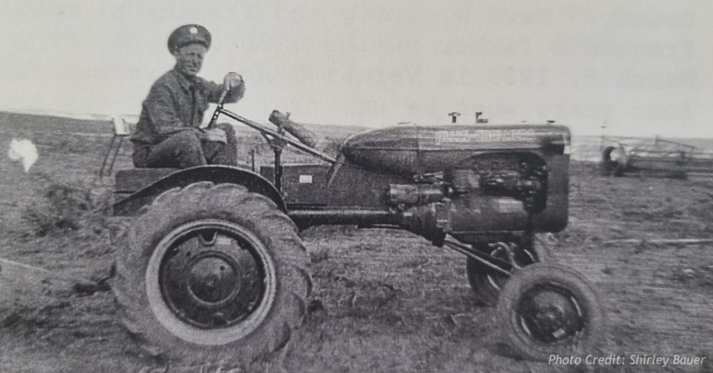 Dave W. Craig in uniform on an Allis-Chalmers tractor in a Colorado field, home on leave around 1944
