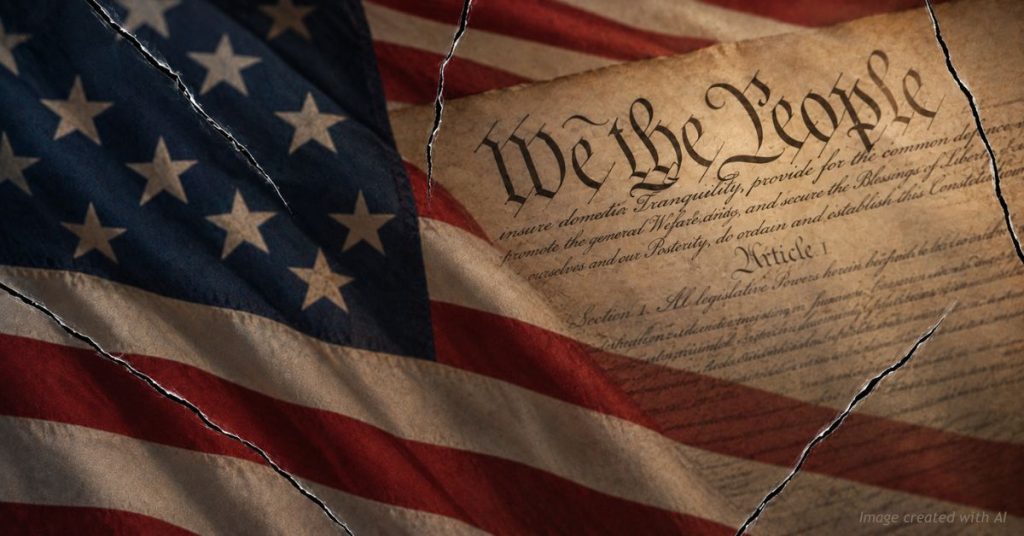 Cracked glass over the U.S. Constitution and flag, symbolizing a system under strain but not yet broken.