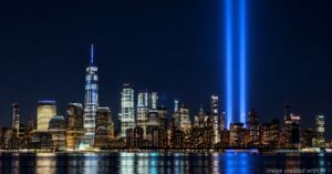 New York City skyline at night with the 9/11 Tribute in Light honoring victims as families continue seeking answers.