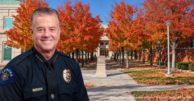 Aurora Police Chief Todd Chamberlain in uniform, with Aurora Police Headquarters and autumn-colored trees in the background.