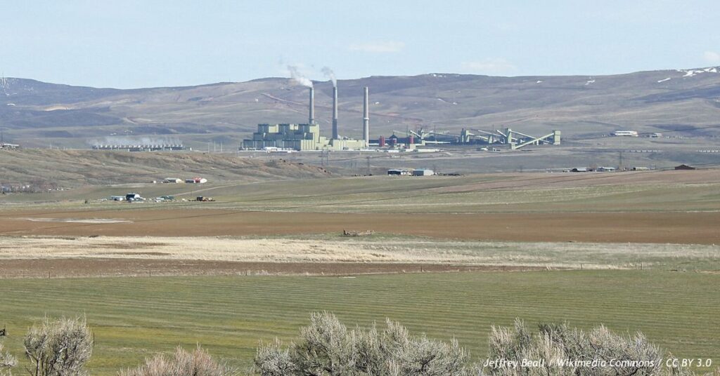 Craig Station coal-fired power plant in Moffat County, Colorado, with three tall smokestacks rising above the facility and surrounding rural landscape.