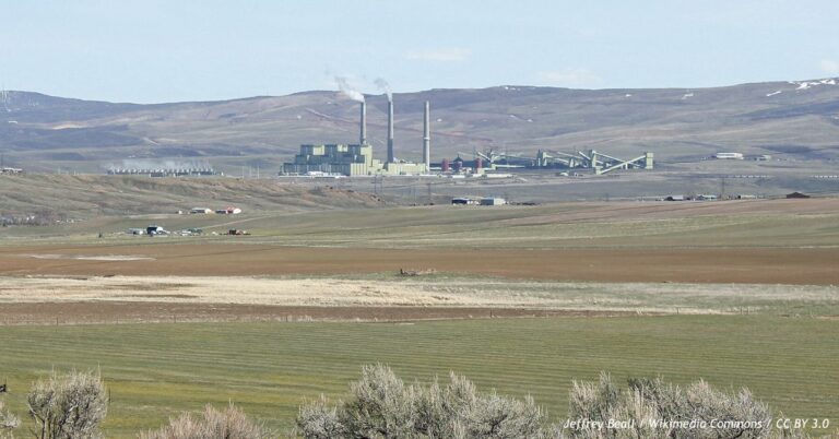 Craig Station coal-fired power plant in Moffat County, Colorado, with three tall smokestacks rising above the facility and surrounding rural landscape.