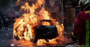 Paris firefighters extinguish a burning car outside a manga shop during riots and demonstrations on October 17, 2026.